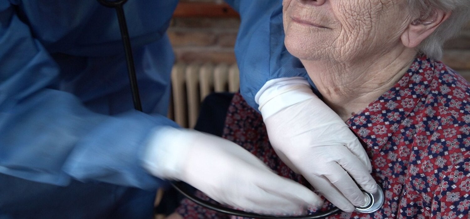  Un miembro del personal de la clínica ayuda a una mujer mayor.