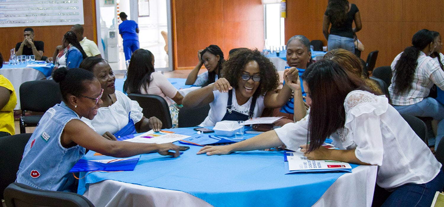 Women interacting seated around a table