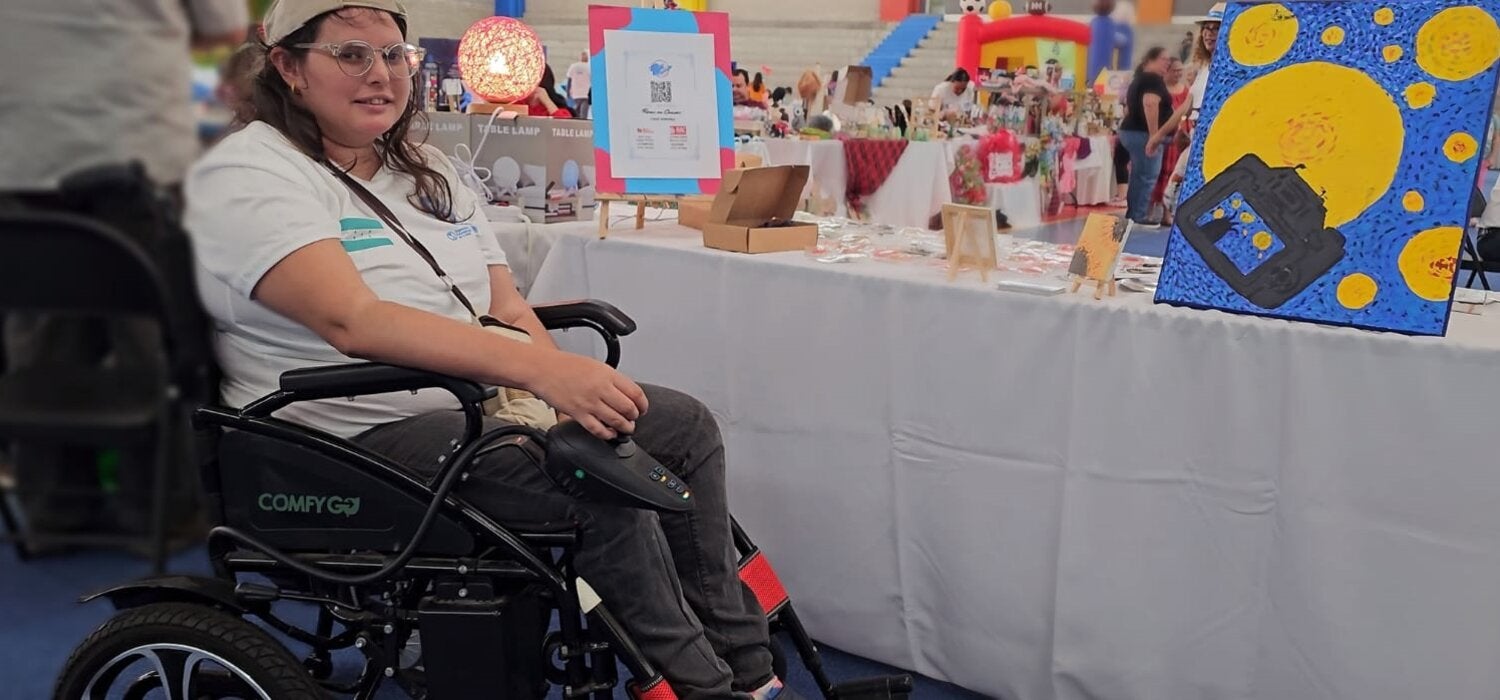 persona en silla de ruedas en feria de emprendedores
