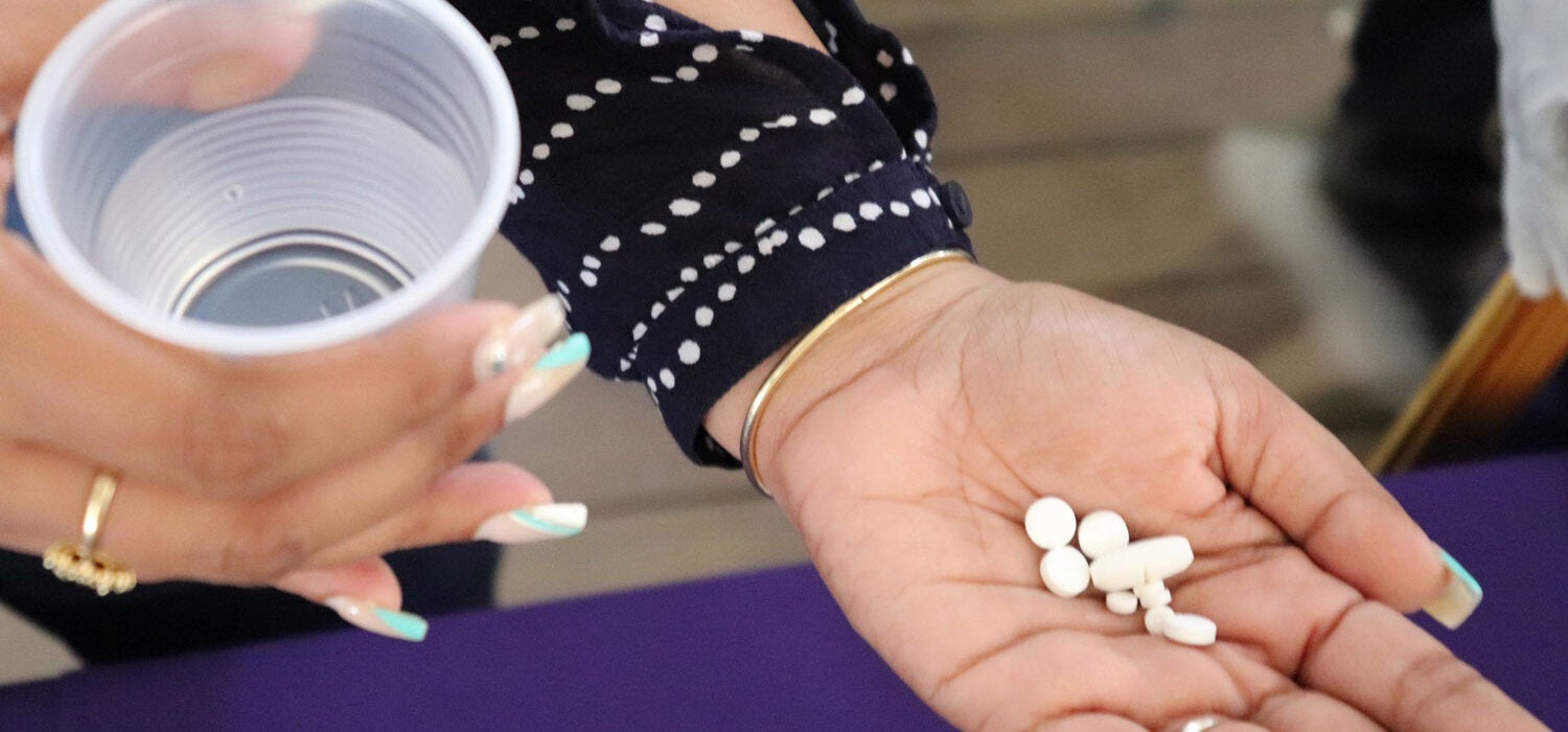Treatment for lymphatic filariasis. Woman hold pills on her hand.