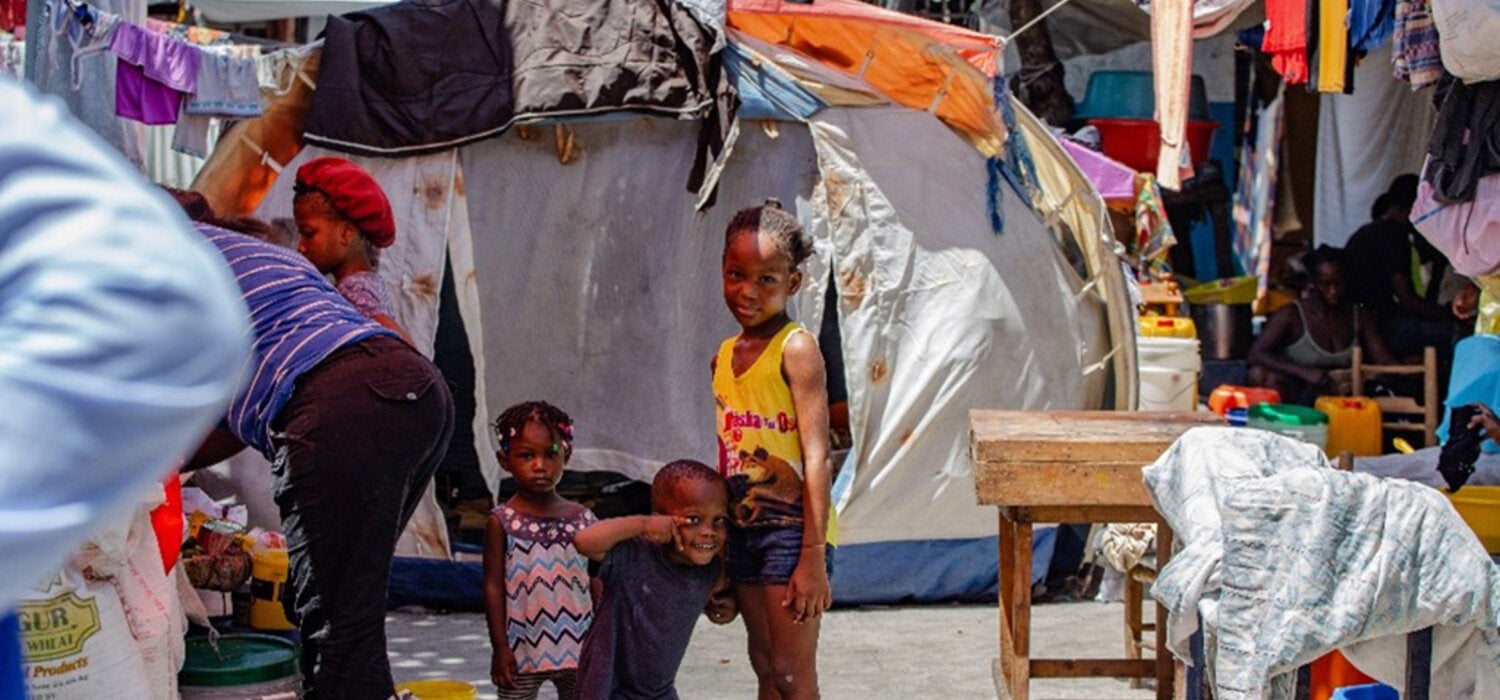 Children smile at camera at a camp in Haiti