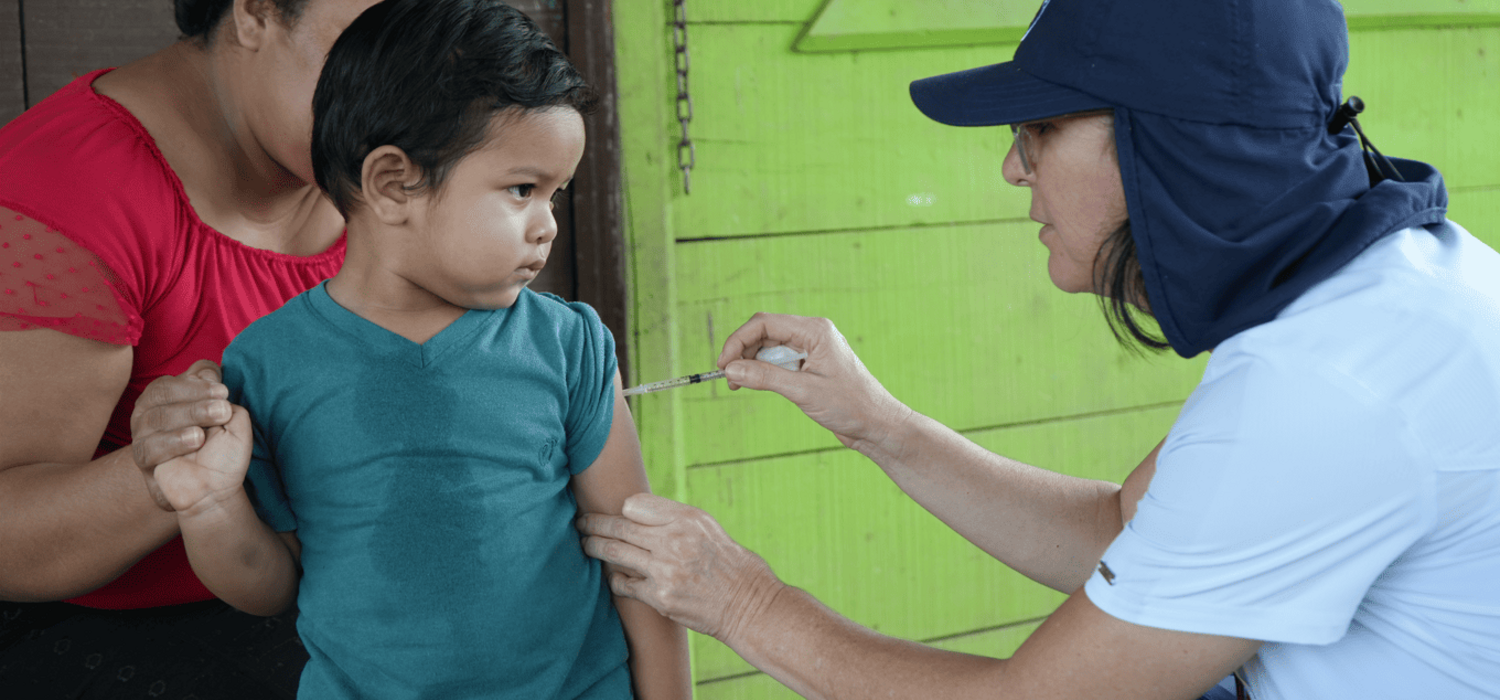 Un niño recibiendo en su casa la dosis pendiente de la vacuna contra sarampión, rubéola y paperas