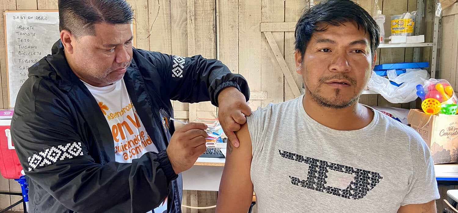 Le nurse Paulo Trindade vaccine un enfant autochtone dans une école.