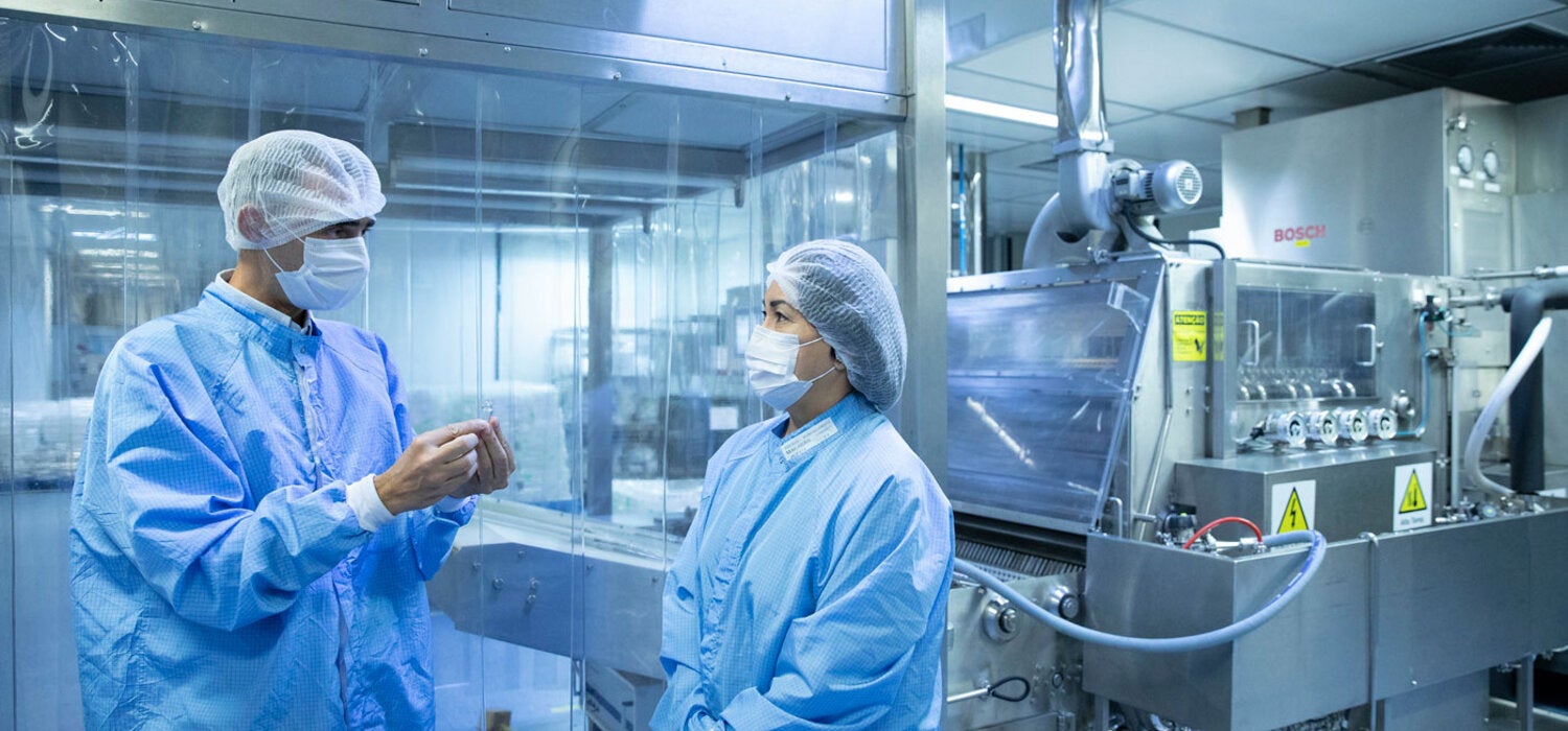 Luiz Lima, Deputy Director of Production at Bio-Manguinhos-Fiocruz, working with a colleague.