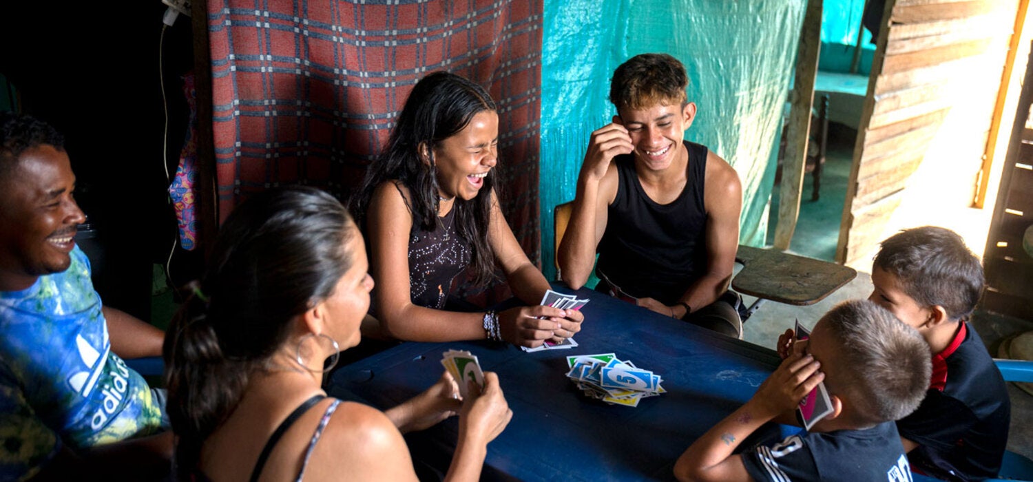 Una familia juega cartas: padres e hijos.
