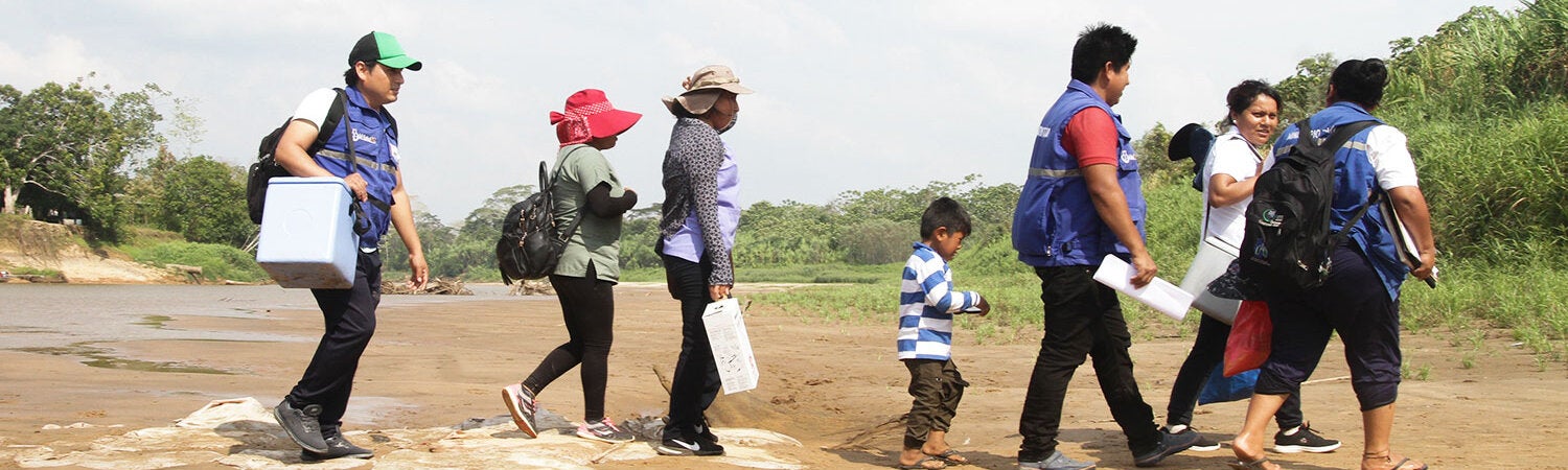 People walking with cold chain freezers in Bolivia