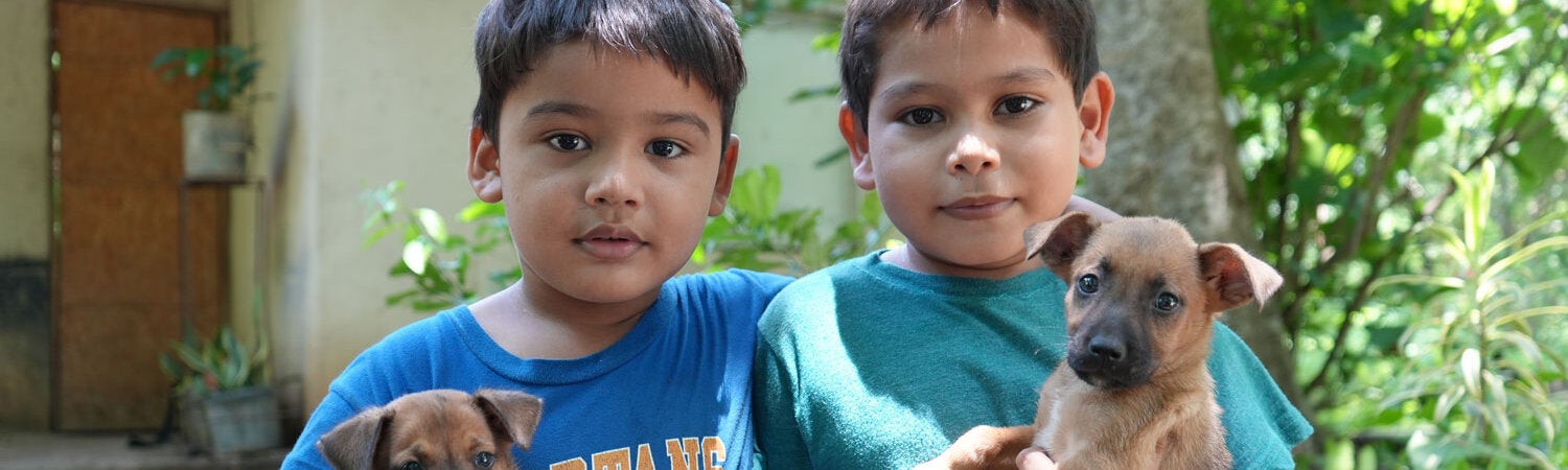 Niños posan con sus cachorros