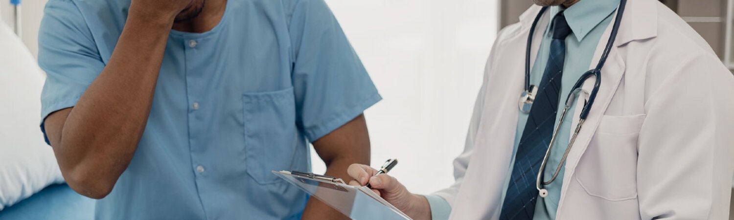 Doctor talking with patient in hospital, male patient lying in bed and doctor providing care, giving advice and encouragement iStock Credit Ashi Sae Yang