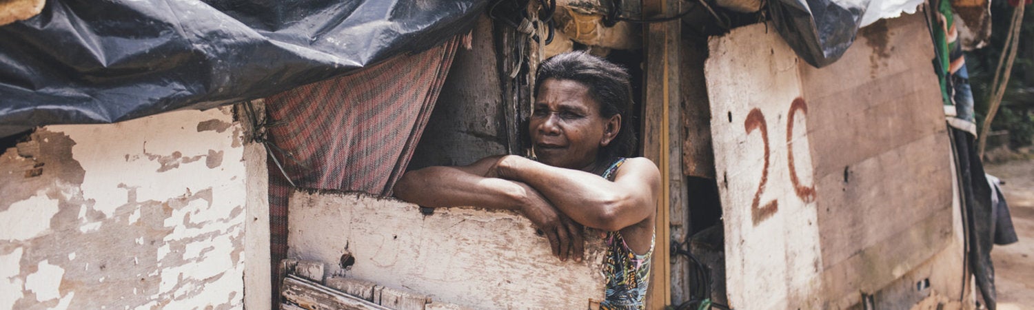 Extreme poverty. Lady outside of her house